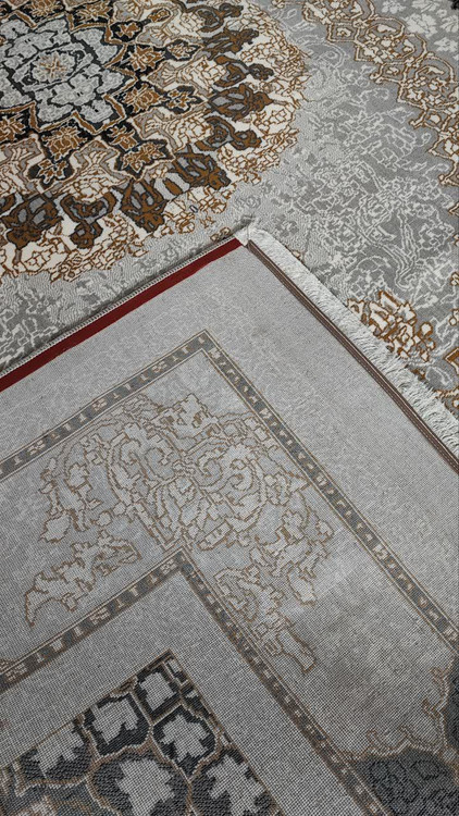 تصویر نزدیک از بافت طلاکوب فرش صدرا نقرهای، با درخشش طلایی روی زمینه نقرهای و نخ پلیاستر با کیفیت