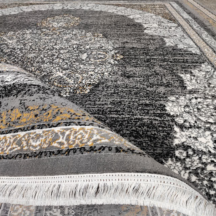 نمای نزدیک از طرح مرکزی فرش گلاب فیلی: نمای زوم شده از نقش گلاب در مرکز فرش گلاب فیلی، با جزئیات گلهای قرینه و ظریف روی زمینه فیلی با بافت پلیاستر درخشان.